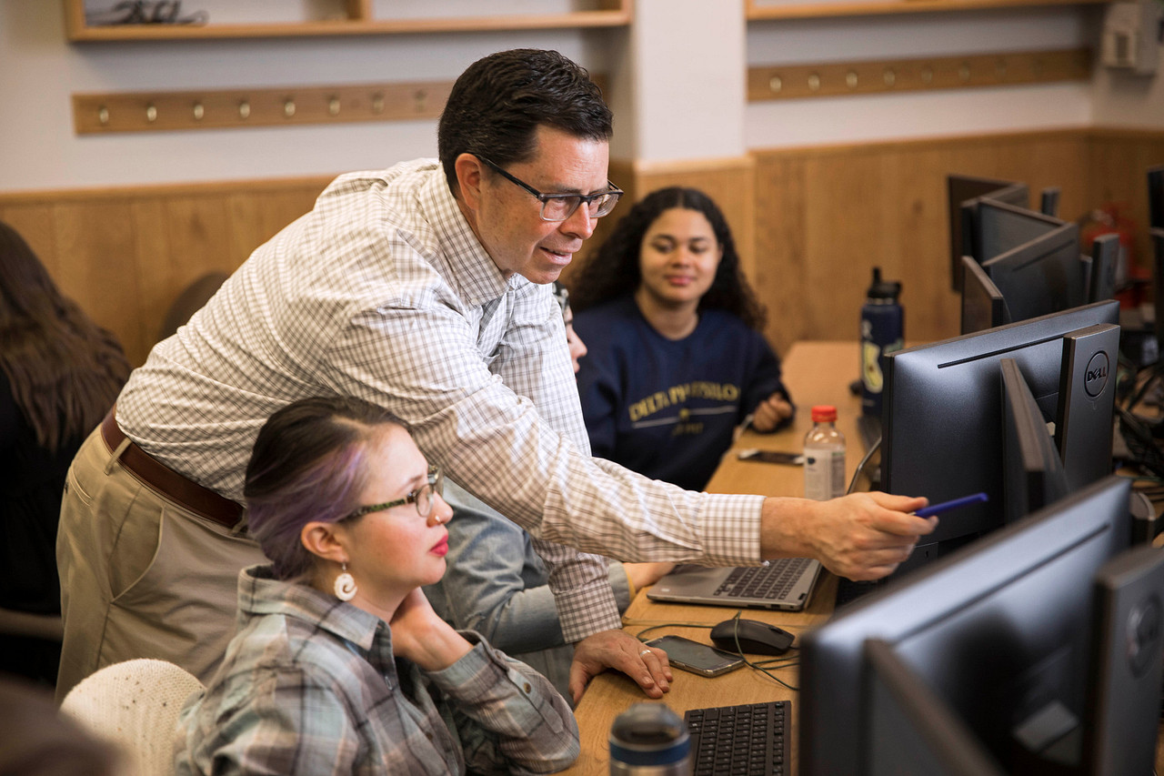 A Northern Arizona University professor pointing at a computer screen.