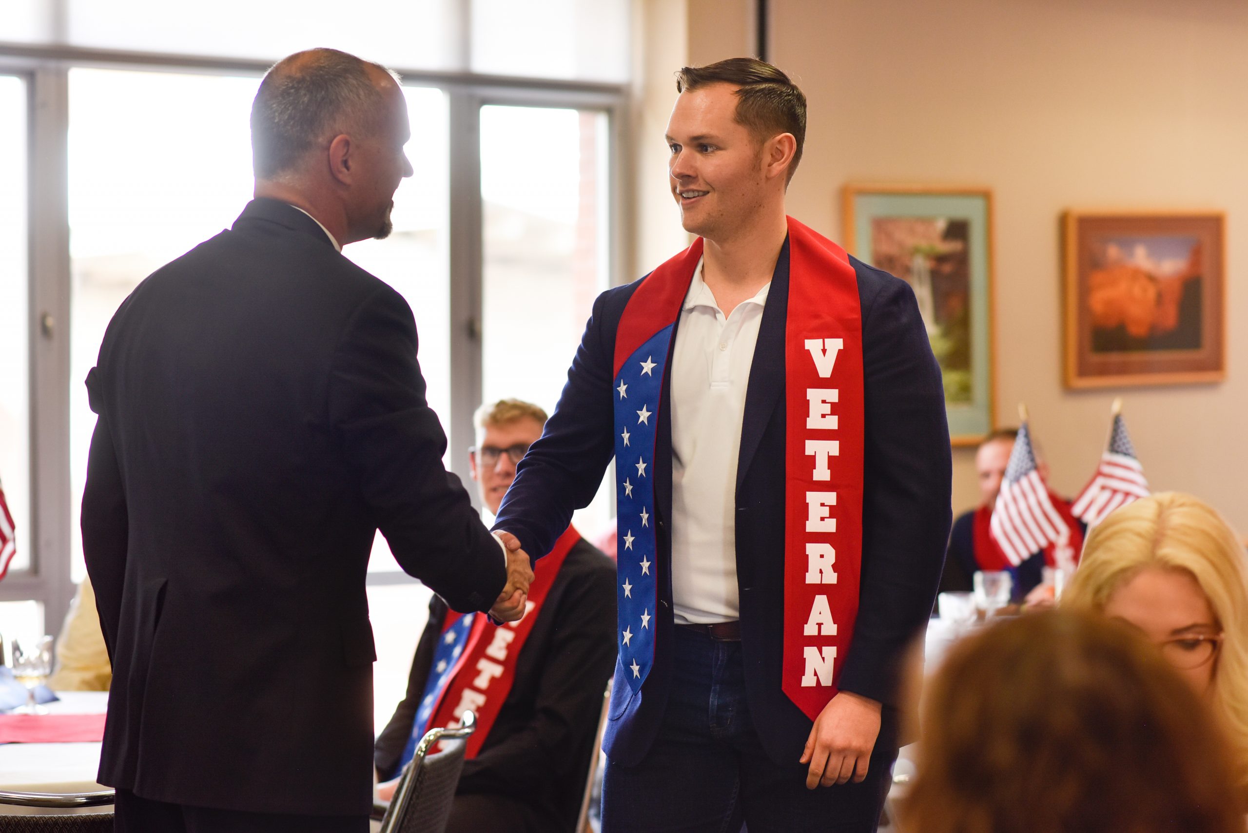 An veteran attending N A U being awarded during commencement.