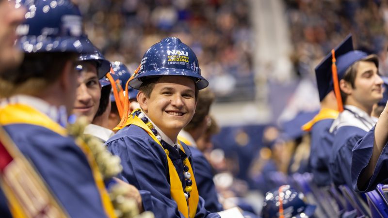 An N A U engineering student smiles happily at commencement.