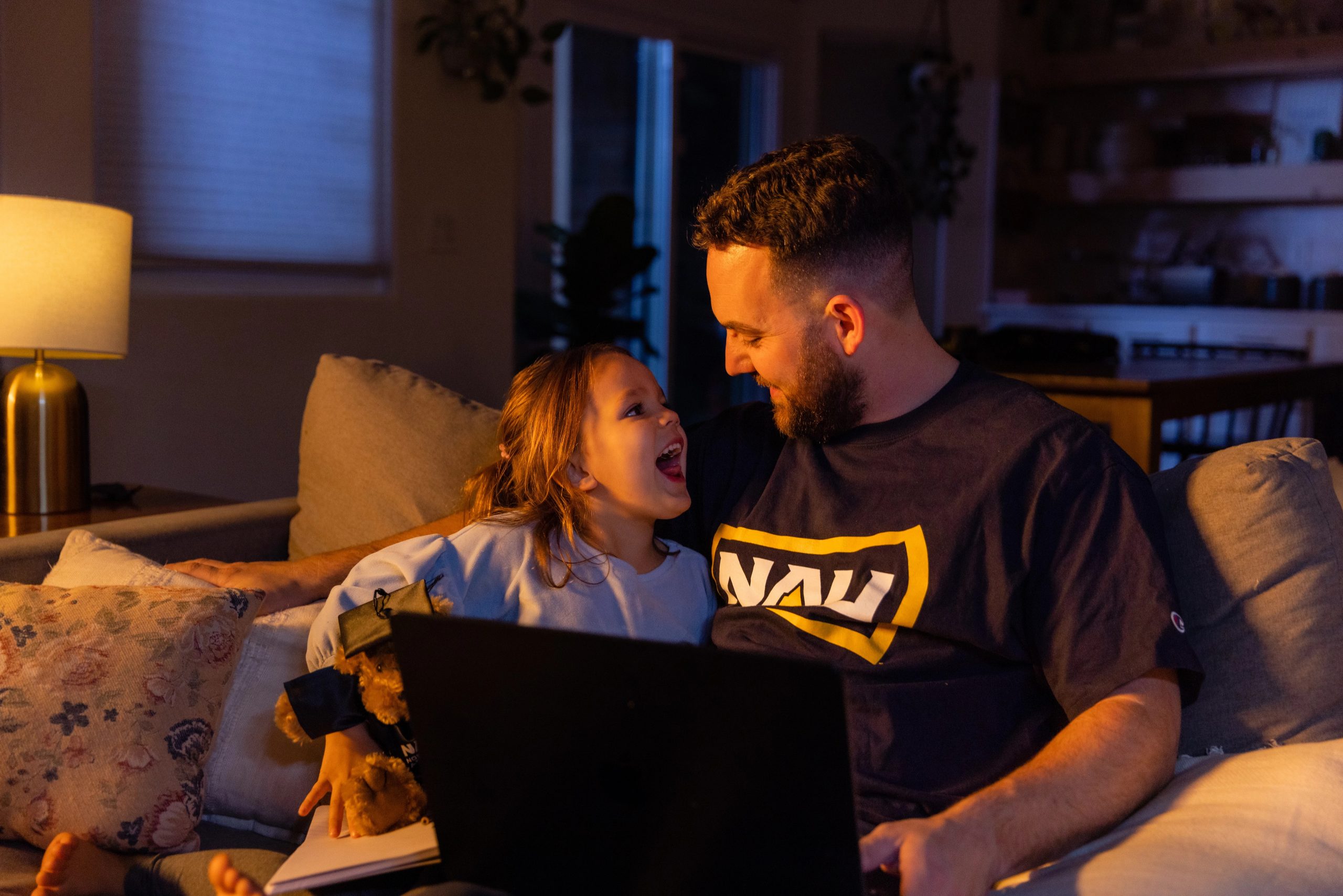 An N A U Online student and parent studies from home with their daughter by their side.