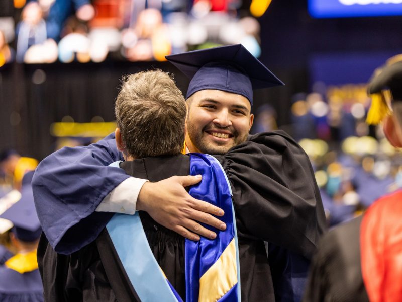 Graduate hugging faculty.