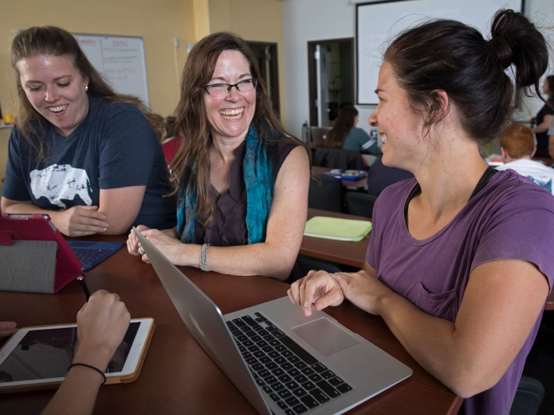 Student laughing and sitting next to each other.
