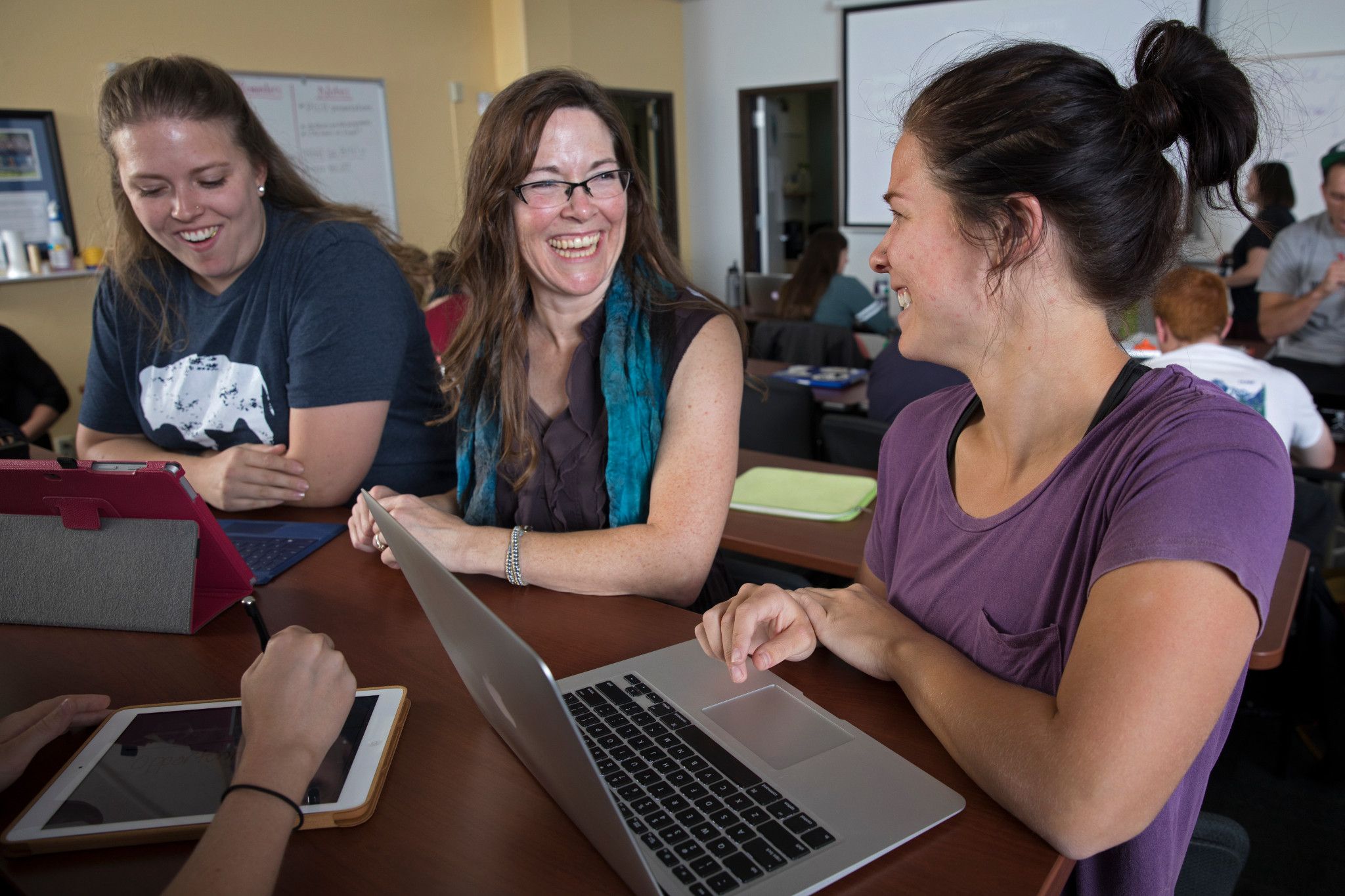 Student laughing and sitting next to each other.