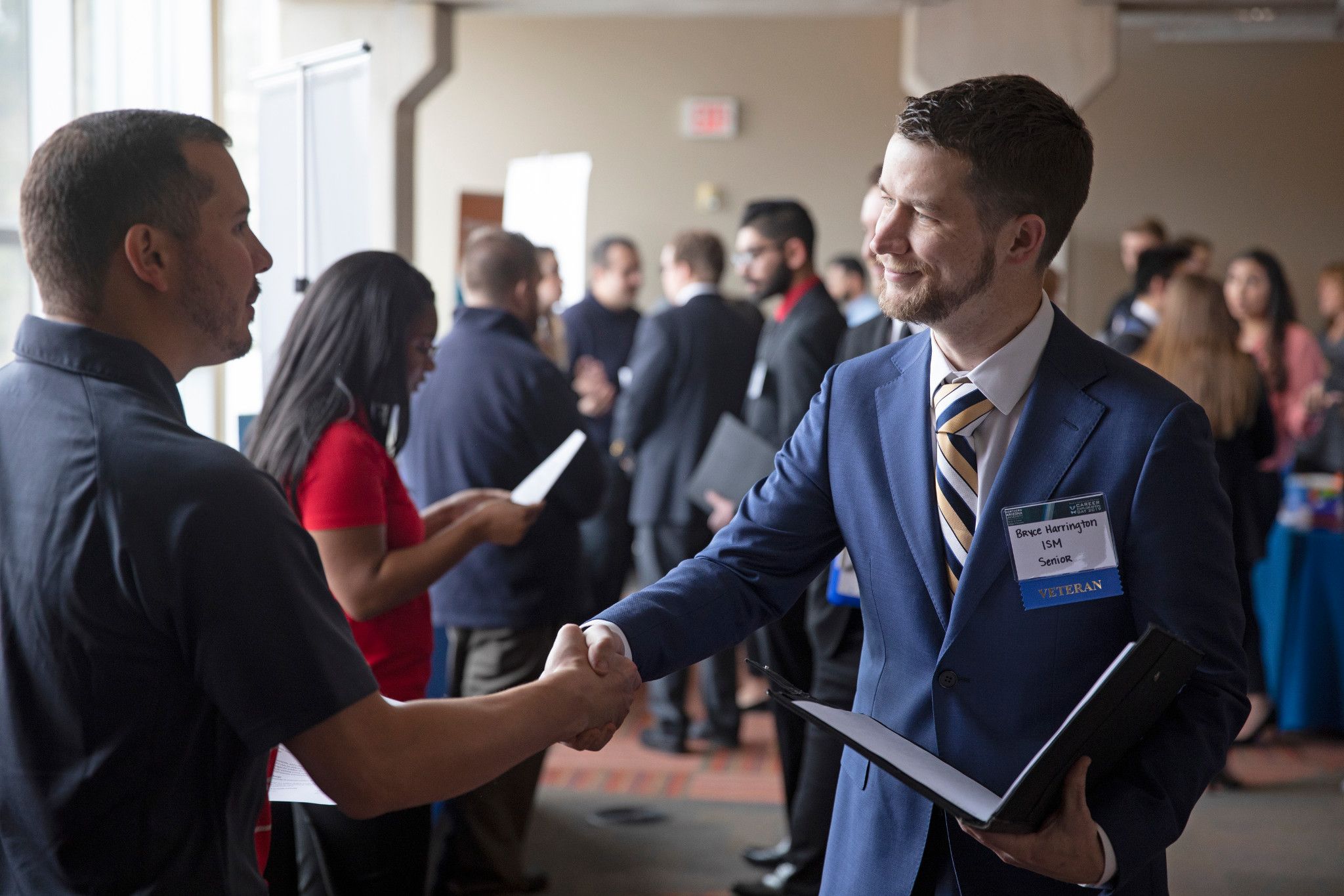 Student and recruiter shaking hands.