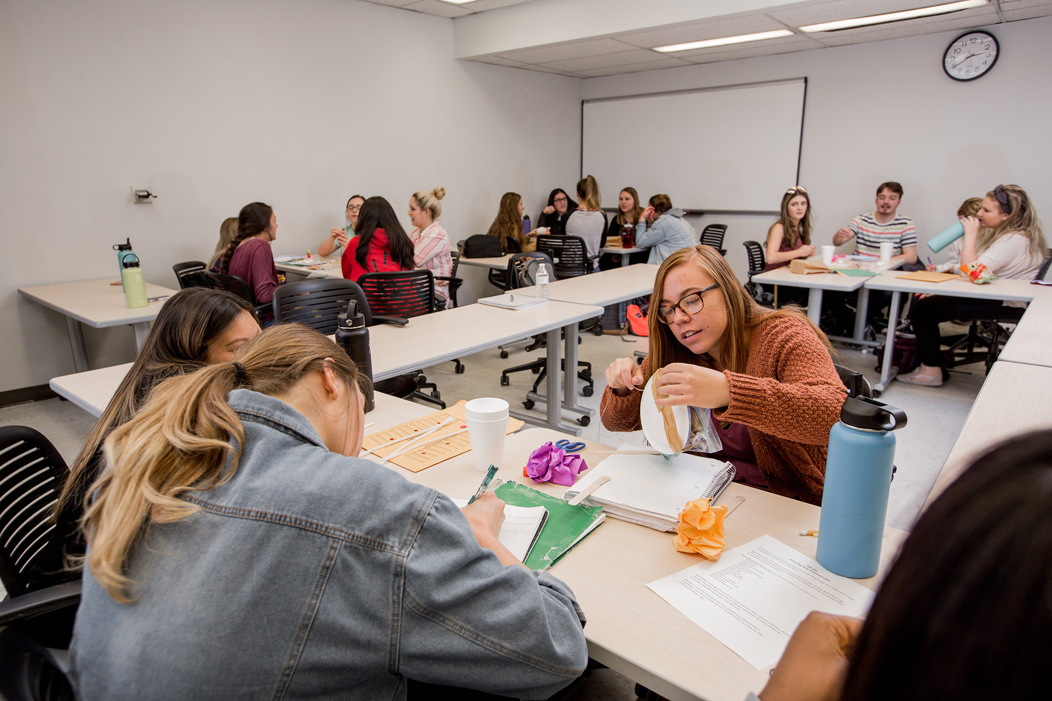 Classroom full of students working in groups on a project.