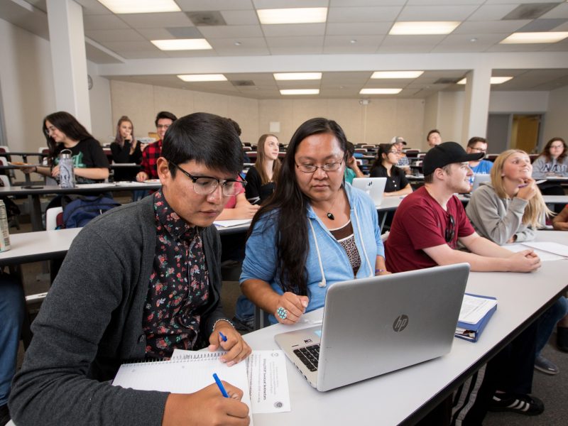 Classroom full of N A U students who are working together laptop.