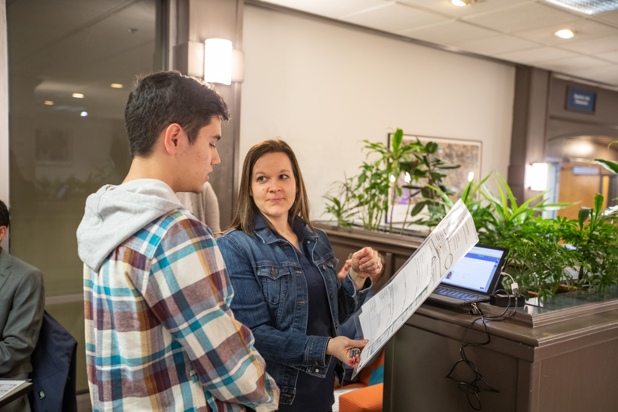 Advisor speaking with student in lobby.