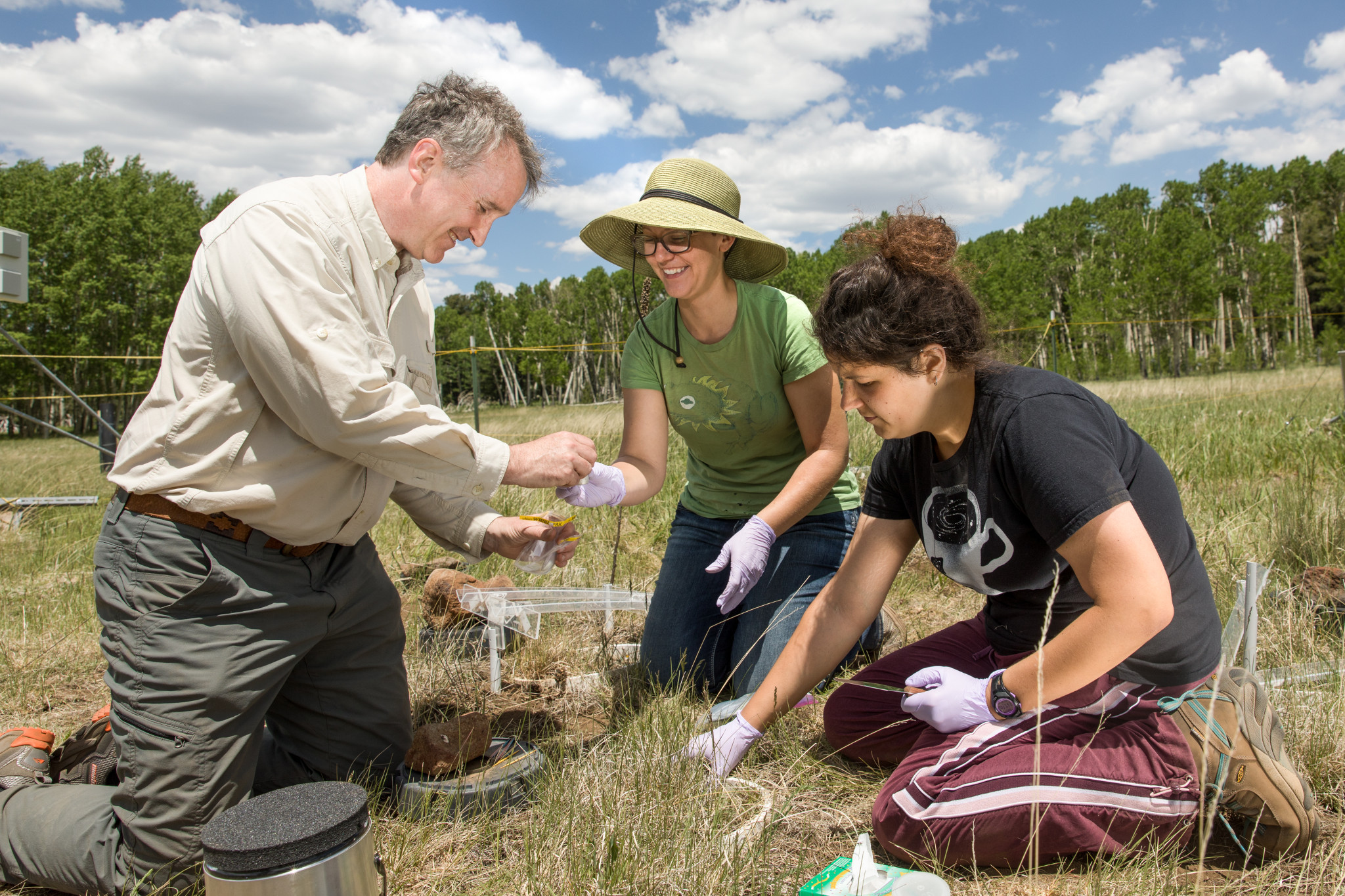 Faculty and student picking up ground samples.
