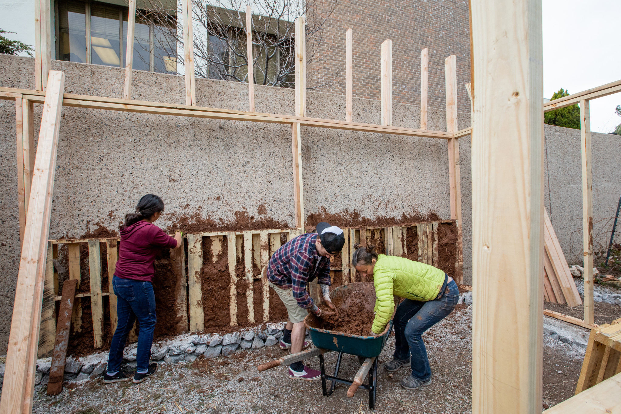 Three students working on building a greenhouse.