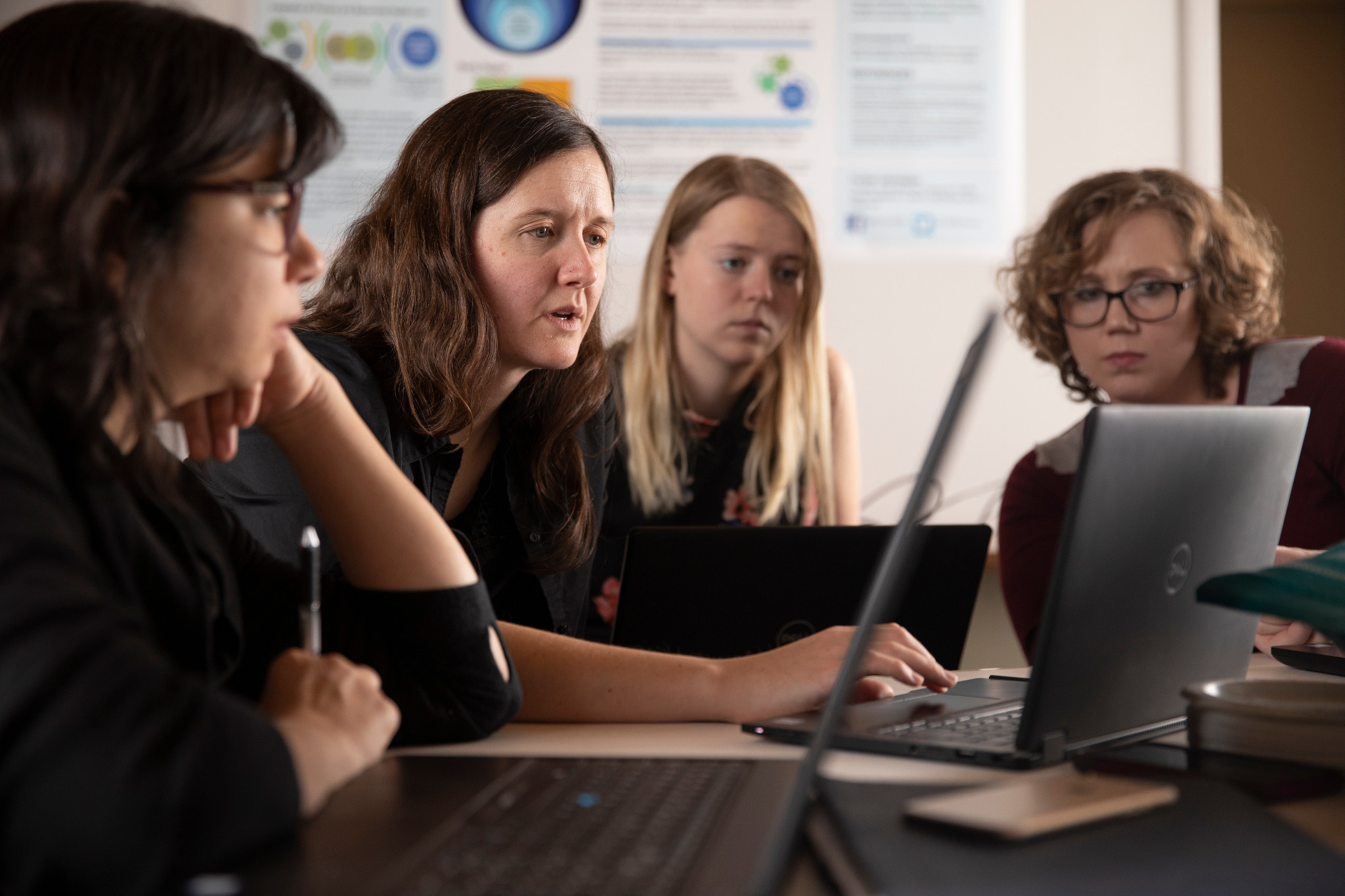 Faculty working together on a laptop.