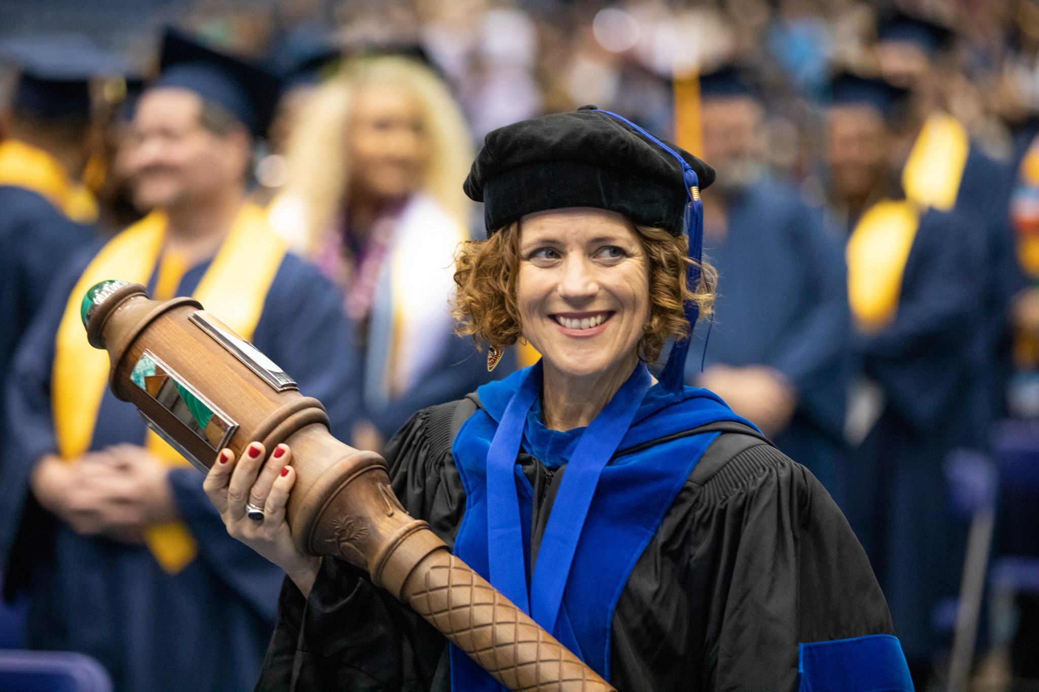 Faculty smiling at graduation.