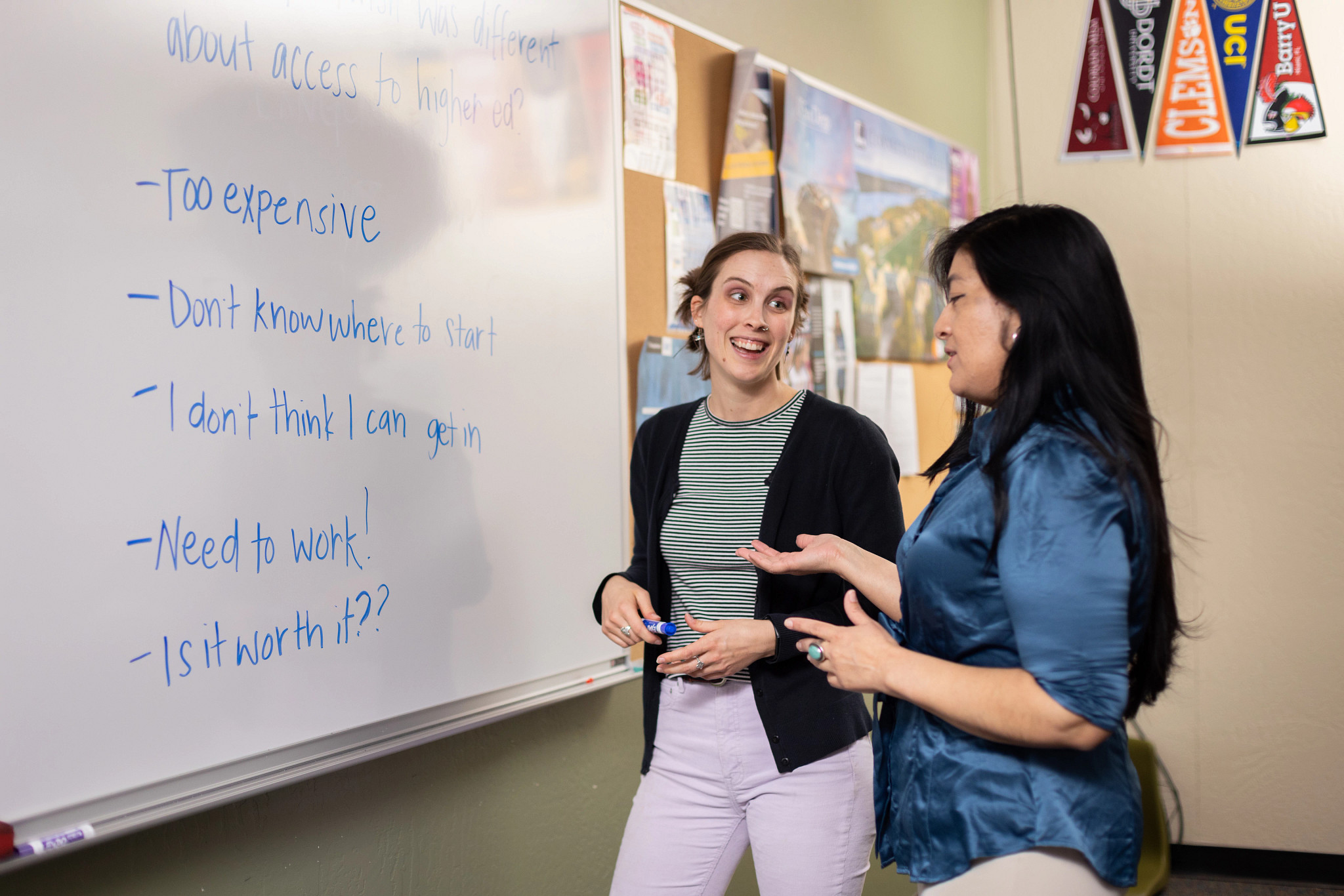 Students discussing topics on a whiteboard.