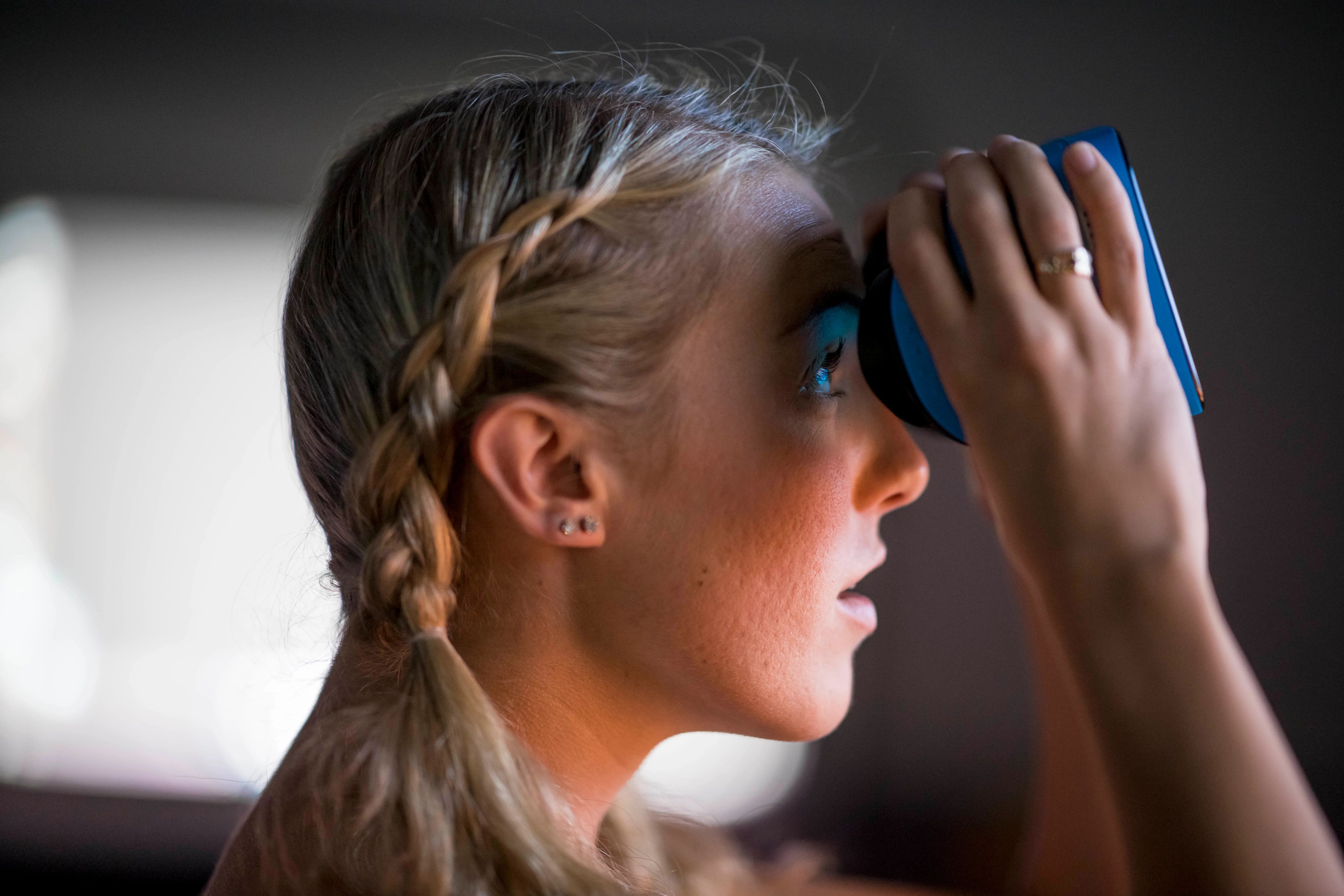 Student looking out window with binoculars.