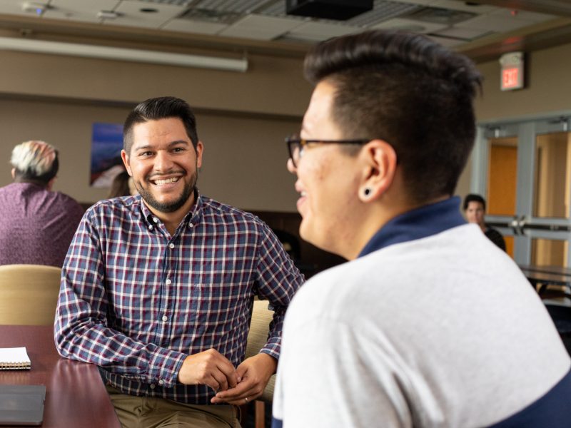 N A U alumni smiling at each other.