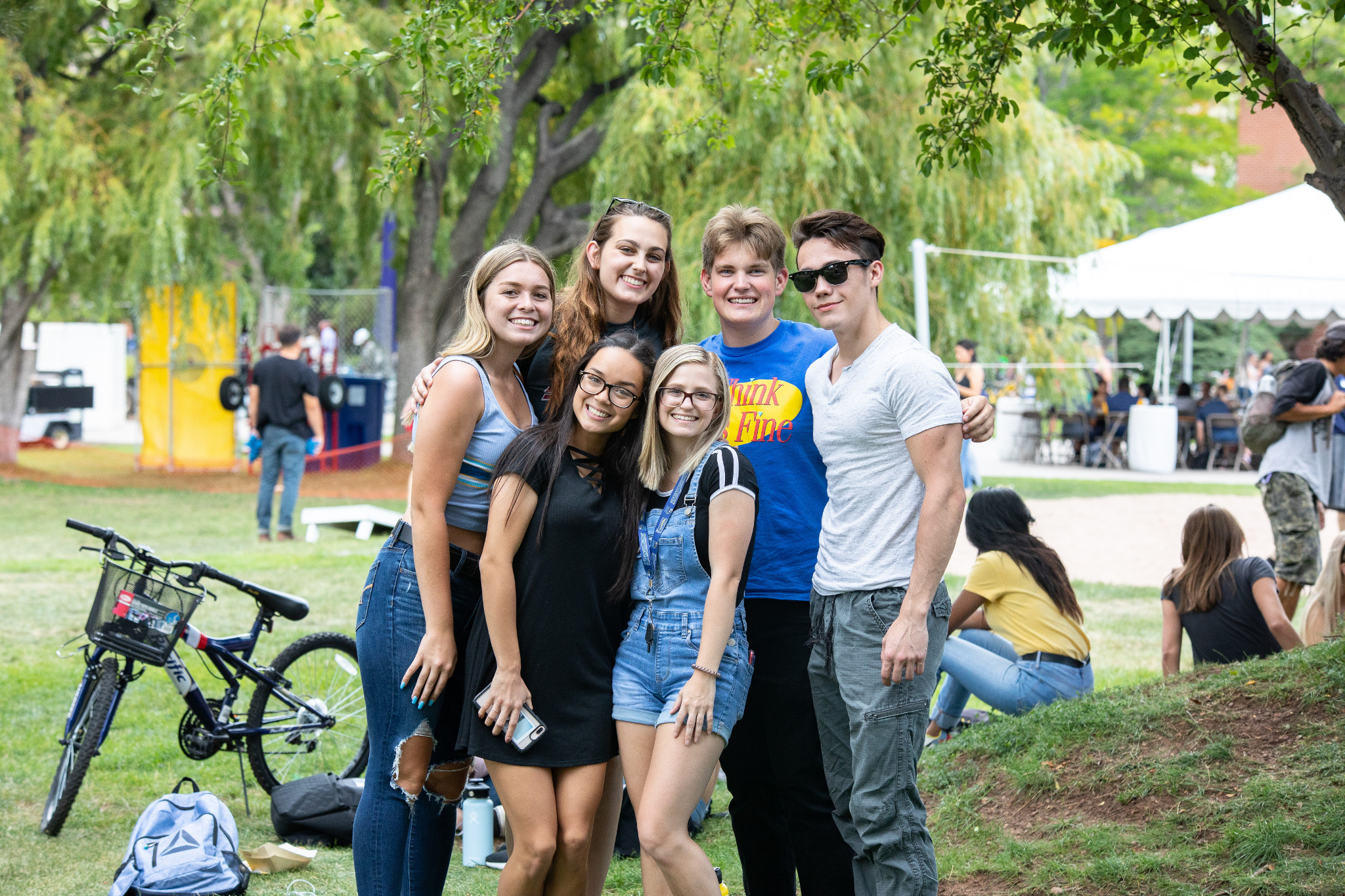 N A U freshmen students and family smiling at the camera in an outdoor quad.