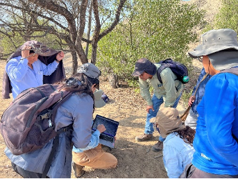 Students and faculty hovering over a computer.