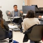 Faculty member and students collaborating in the classroom.