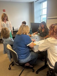 Group of people sitting in a circle in a conference room playing a game