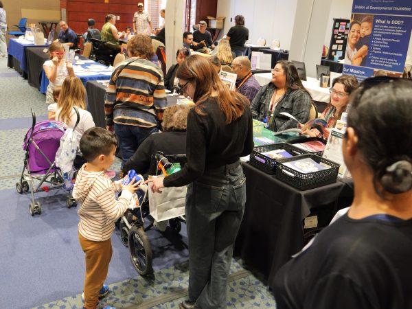 Several people including children in a exhibit hall setting.
