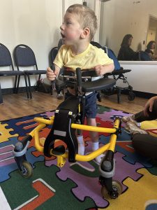 Child using an adapted walker being observed