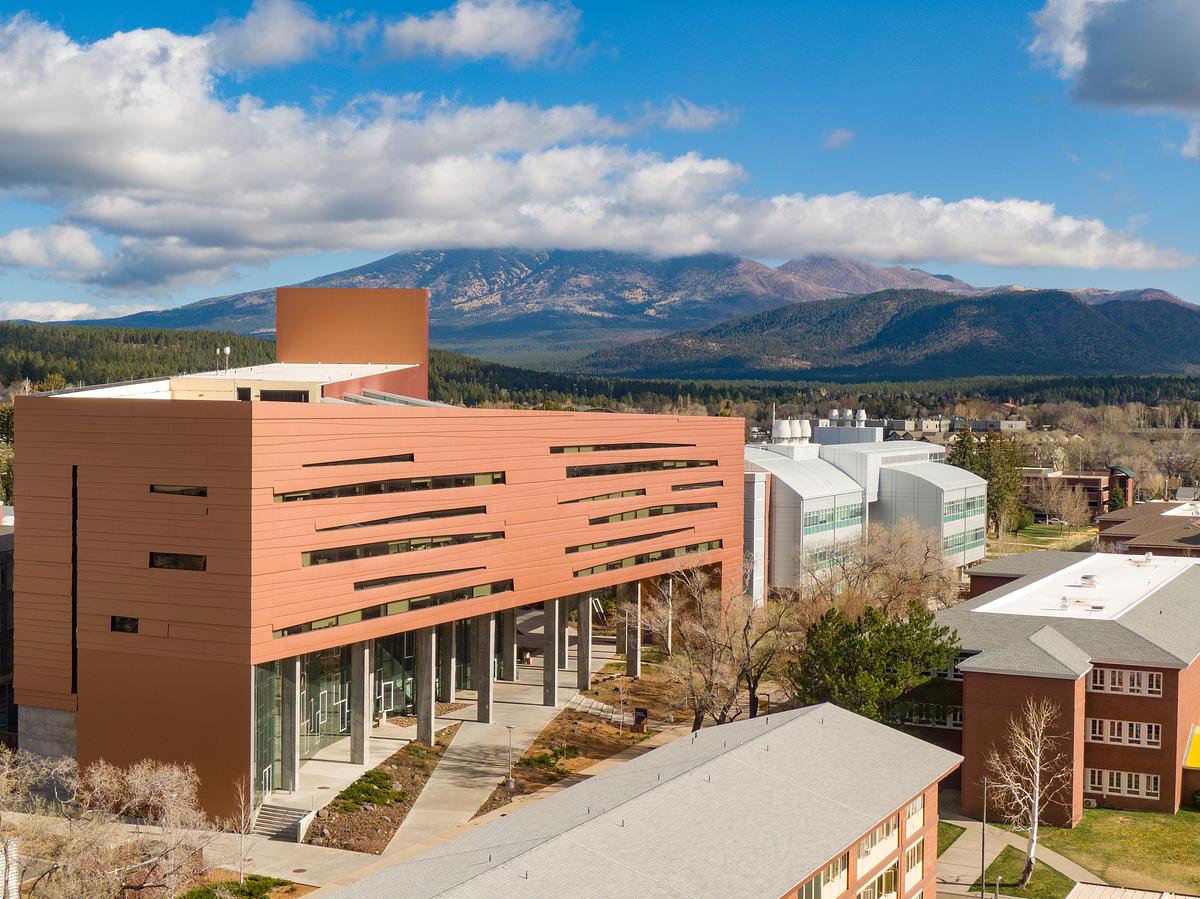 Campus view of the NAU Health building with the San Francisco Peaks in the background.