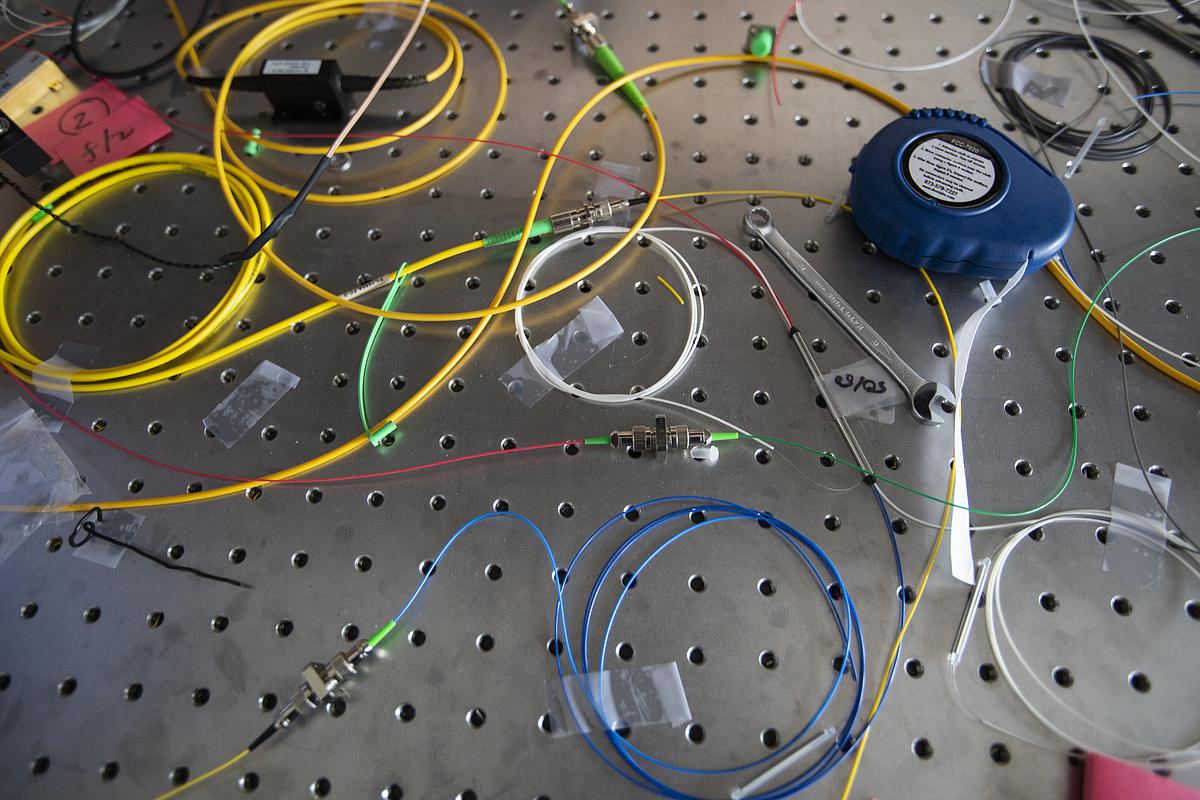 Metal plate with holes and different colored wires taped to the surface.