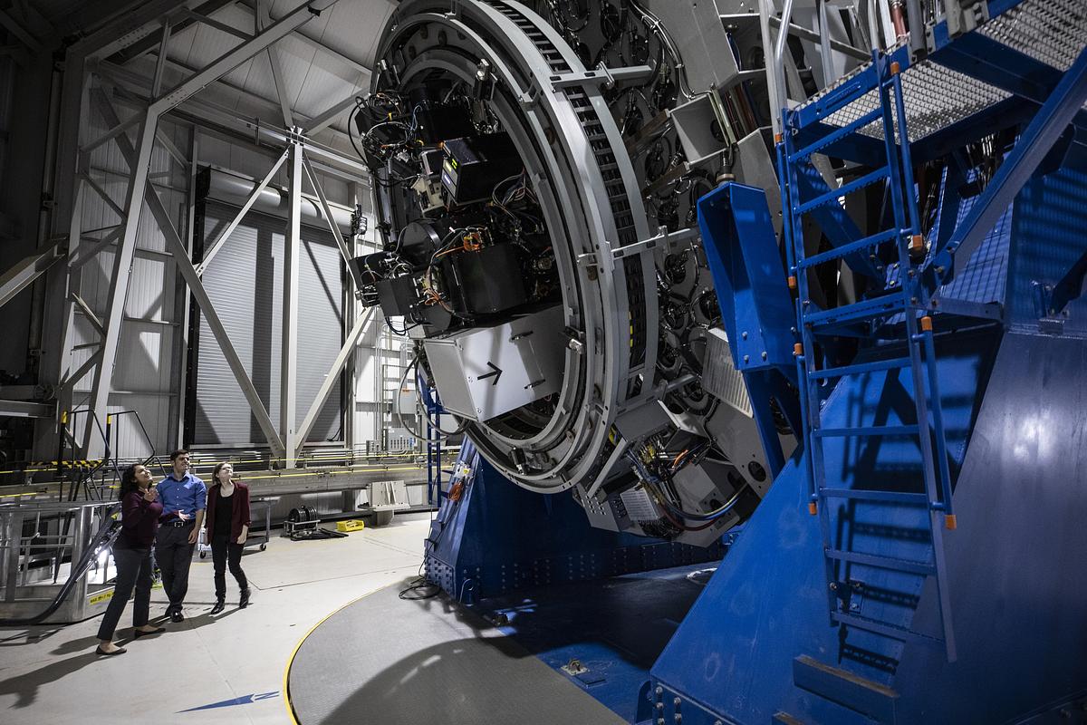 Christina Thomas standing with two research students at the Lowell Discovery Telescope.