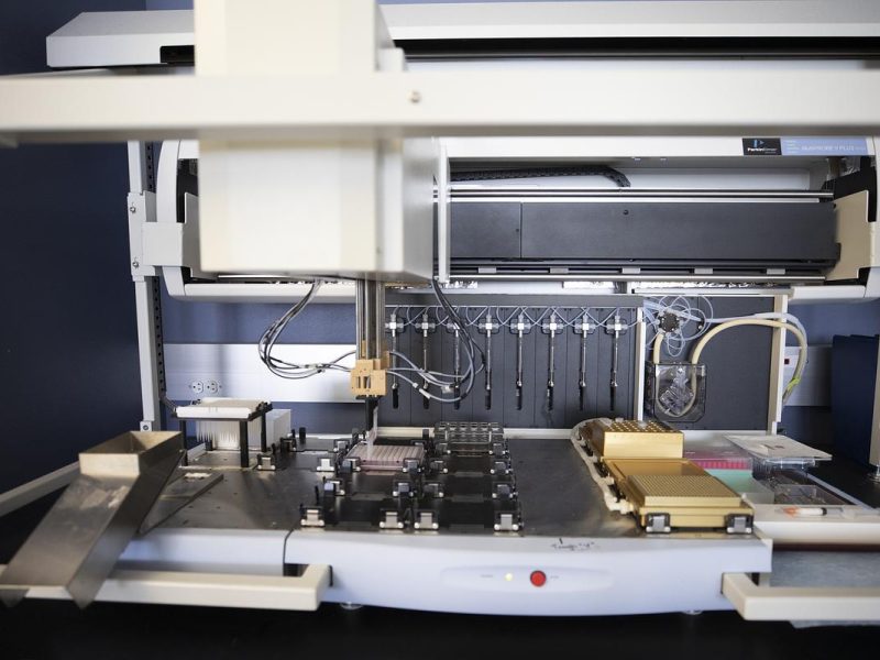 Large machine with multiple components, wires, and tools arranged in an organized manner. Trays and compartments visible, suggesting storage or assembly functions. Complex industrial or manufacturing apparatus.