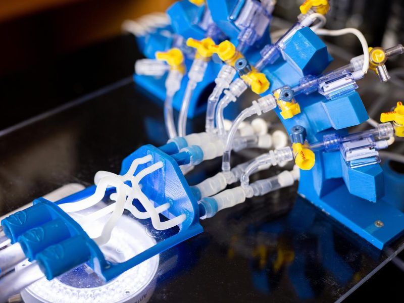 Blue and white mechanical medical device with tubes, valves, and connections.