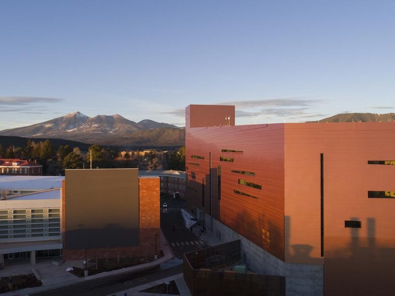 Sunset view of the San Francisco Peaks from the N A U campus with a view of the Health and Science building.