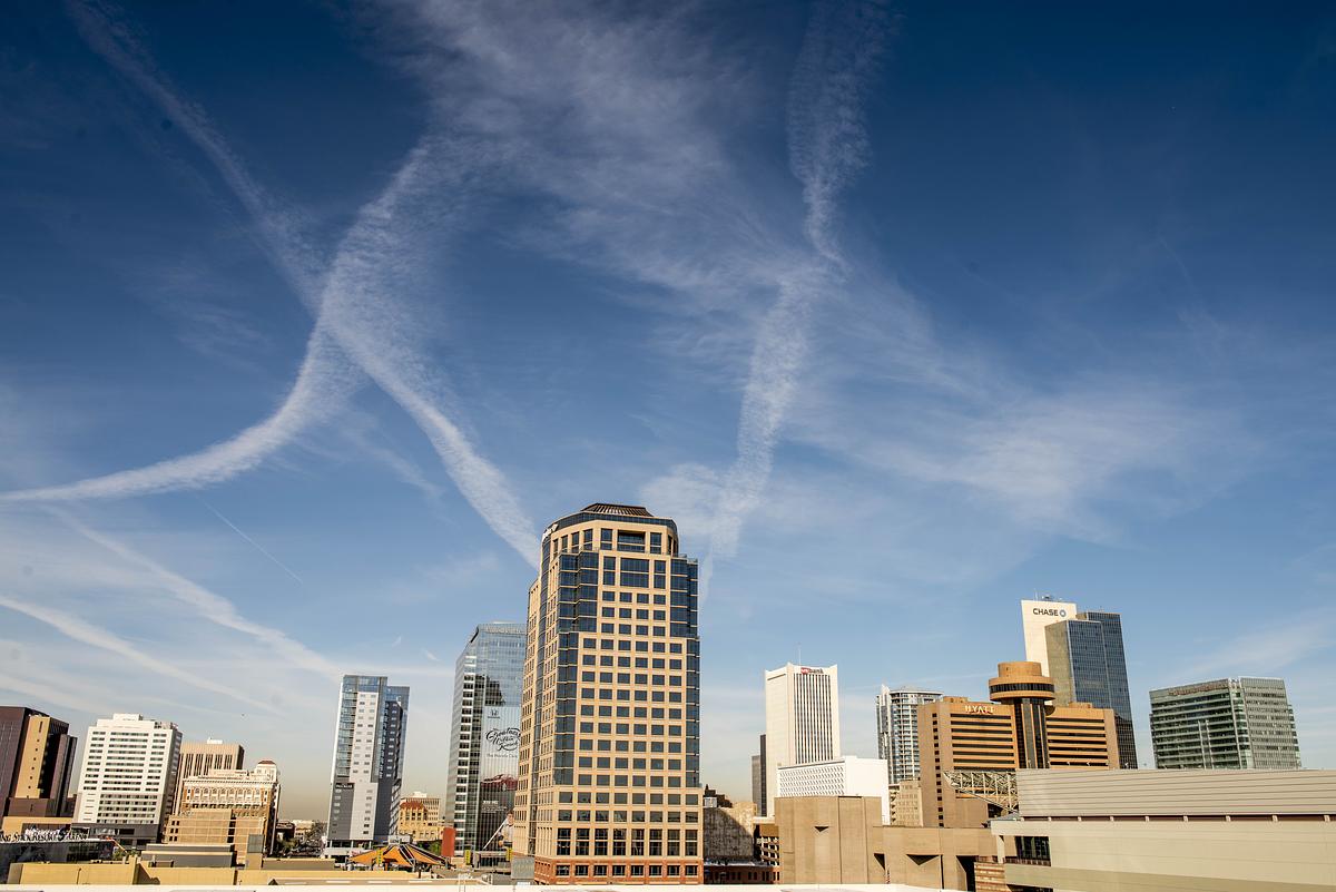 Multiple different size skyscrapers against a blue sky in Phoenix.