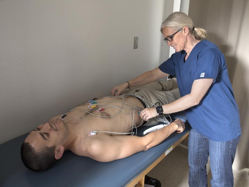 Researcher examining a participant that is laying down on a table.