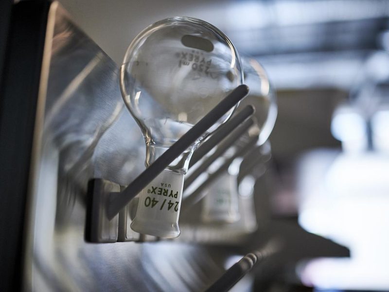 Lab bottles hanging upside down on pegs.