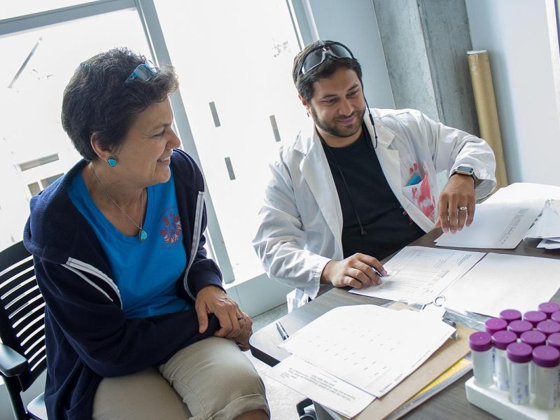 Researcher and student looking at research materials in a lab.