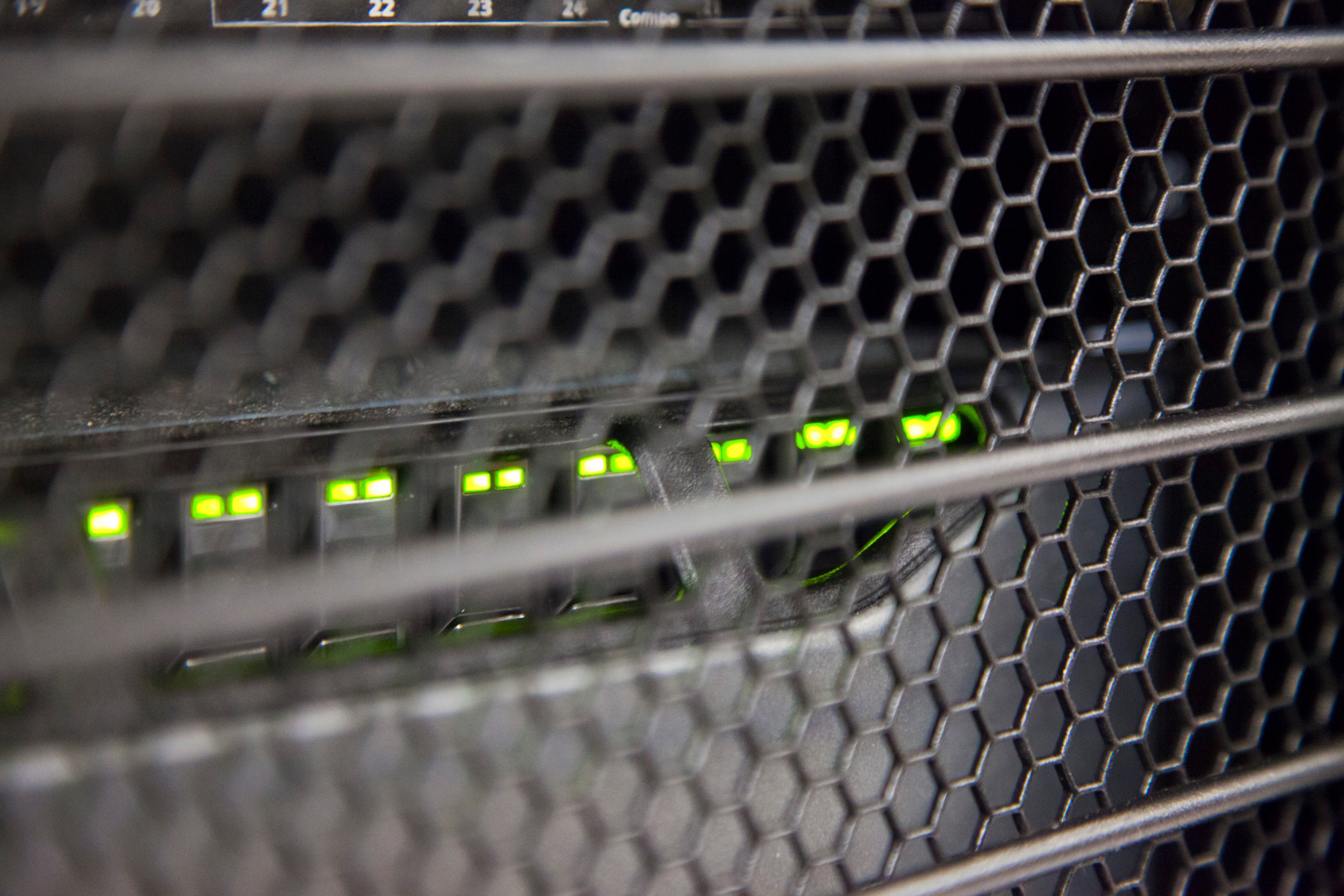 Array of green lights on a hexagonal mesh grid.