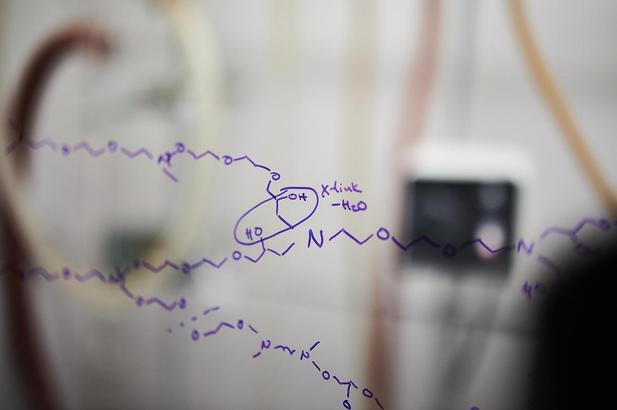 Handwritten notes on a surface, with shapes, lines in purple. It appears to be a scientific formula.