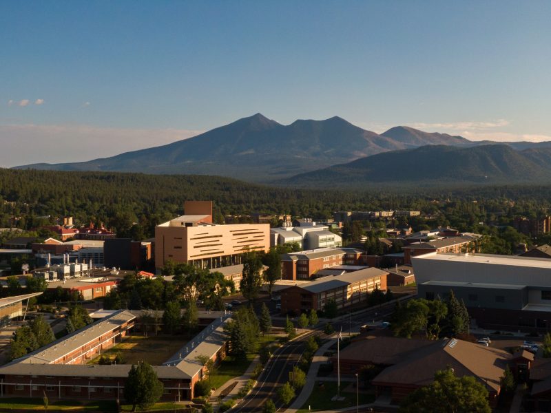 N A U campus with city buildings, roads, and mountains in the distance.