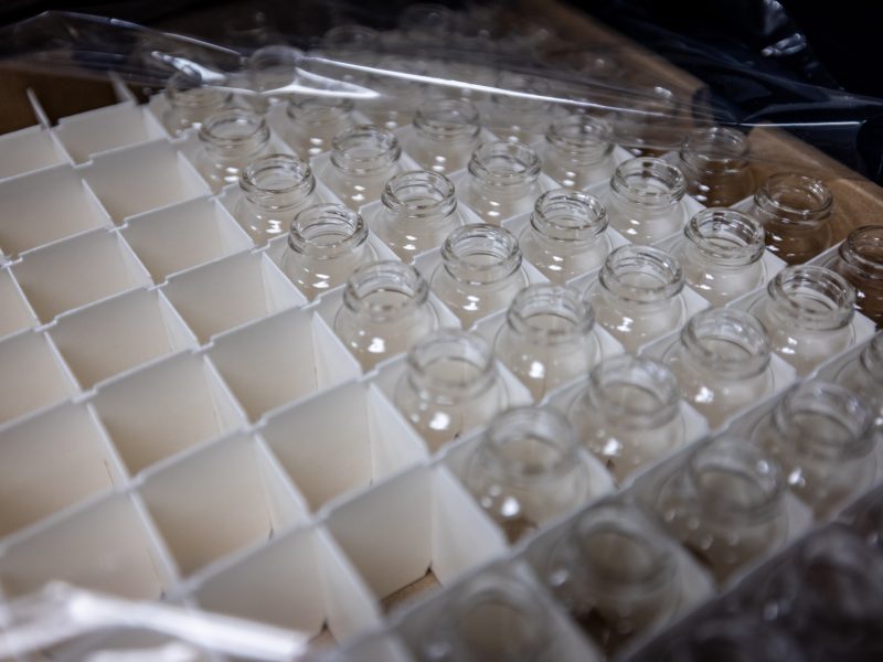 Transparent and white chess pieces on a checkered board. Assorted clear glass containers with lids.