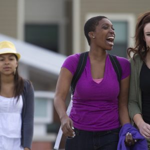 Two students laughing and walking together on campus.
