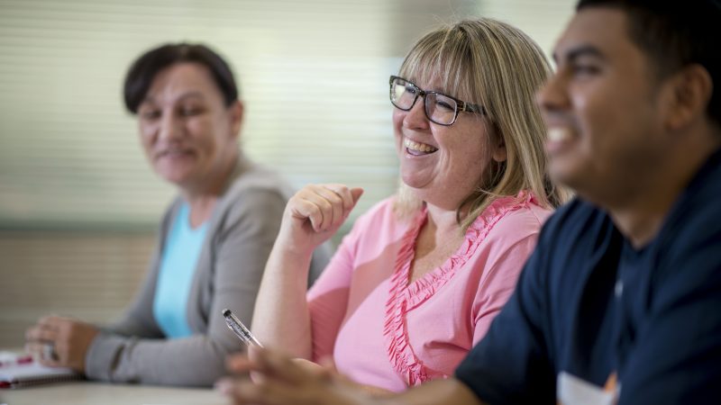 Students sitting in class and smiling.