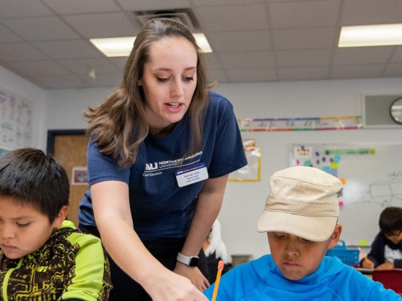 Student teacher helping a students with an assignment.