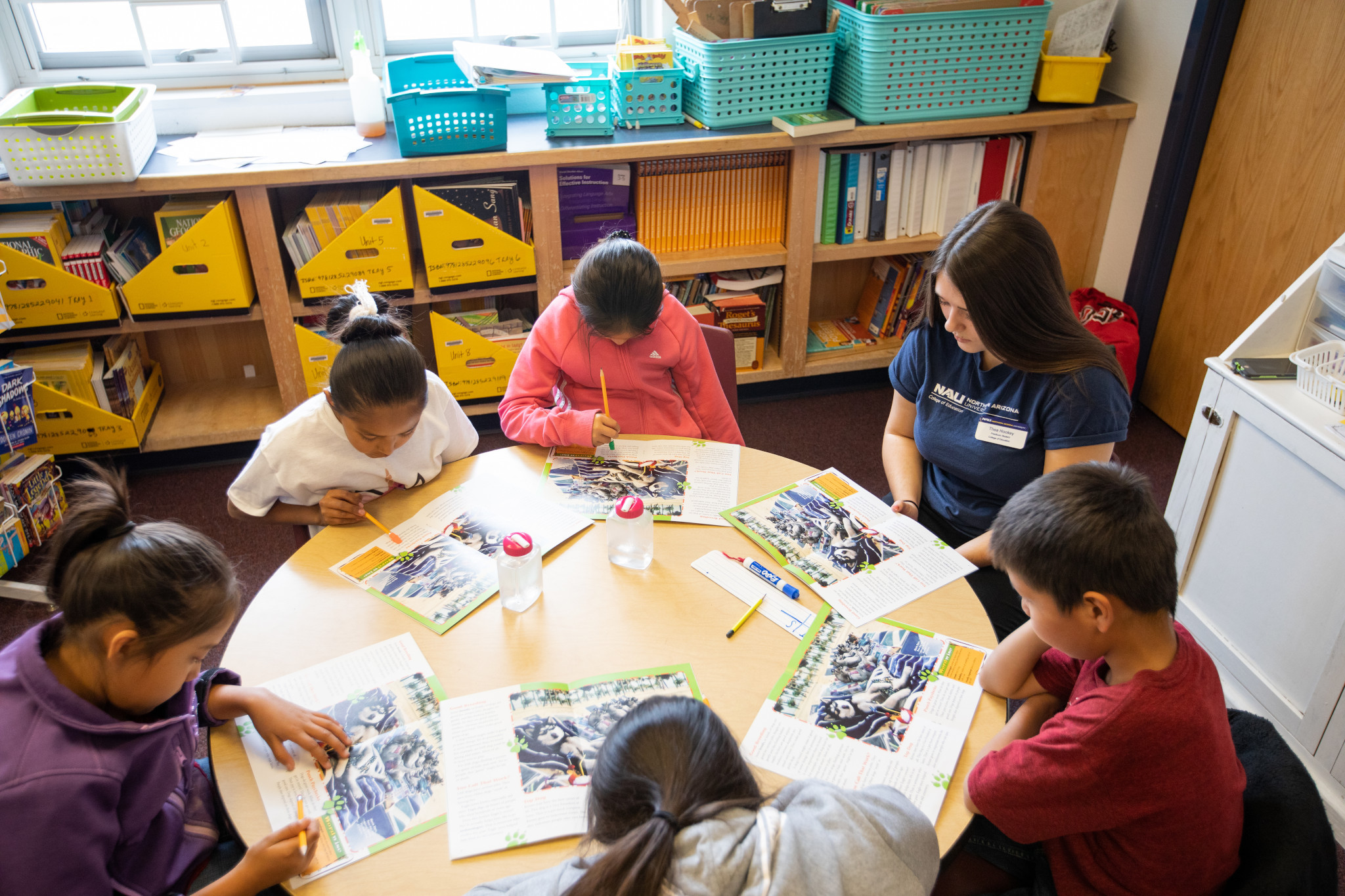 Student teacher sitting at a table with students.