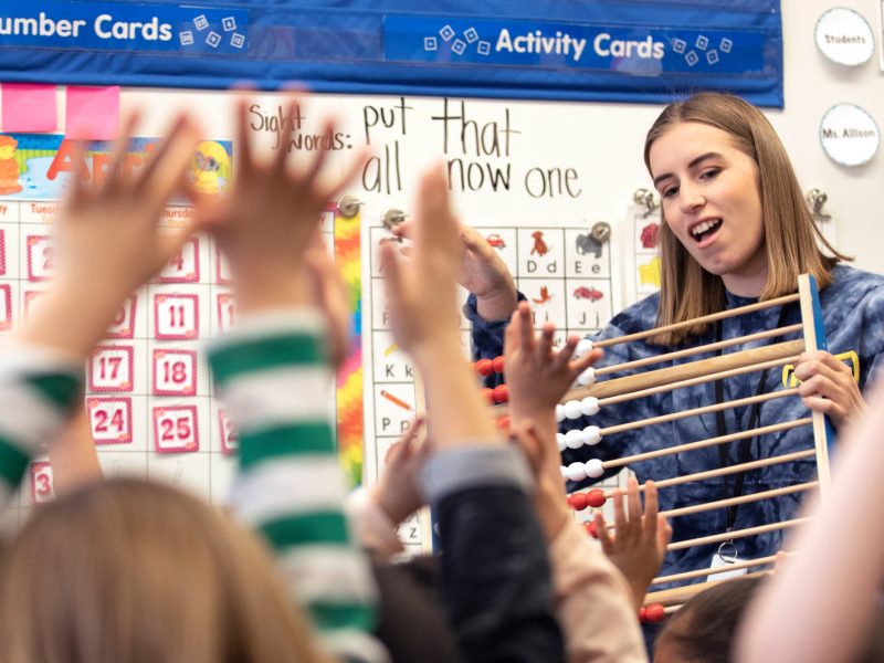 N A U student teacher sitting in front of students and teaching them.