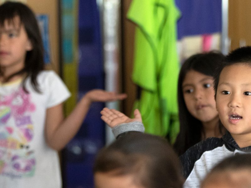 Young students standing in classroom.