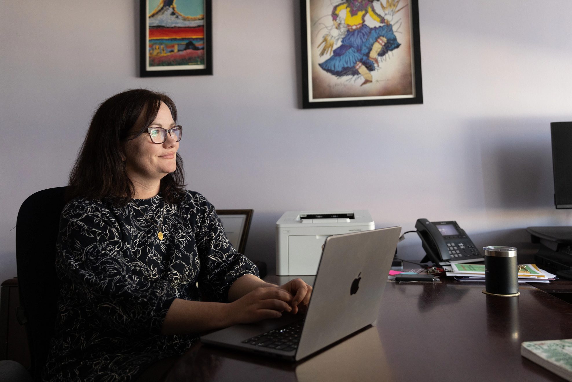 N A U professor sitting at desk and working on laptop.