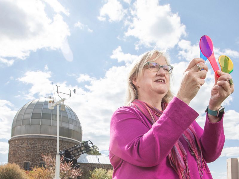 Marti Canipe holding colorful items and looking at them.