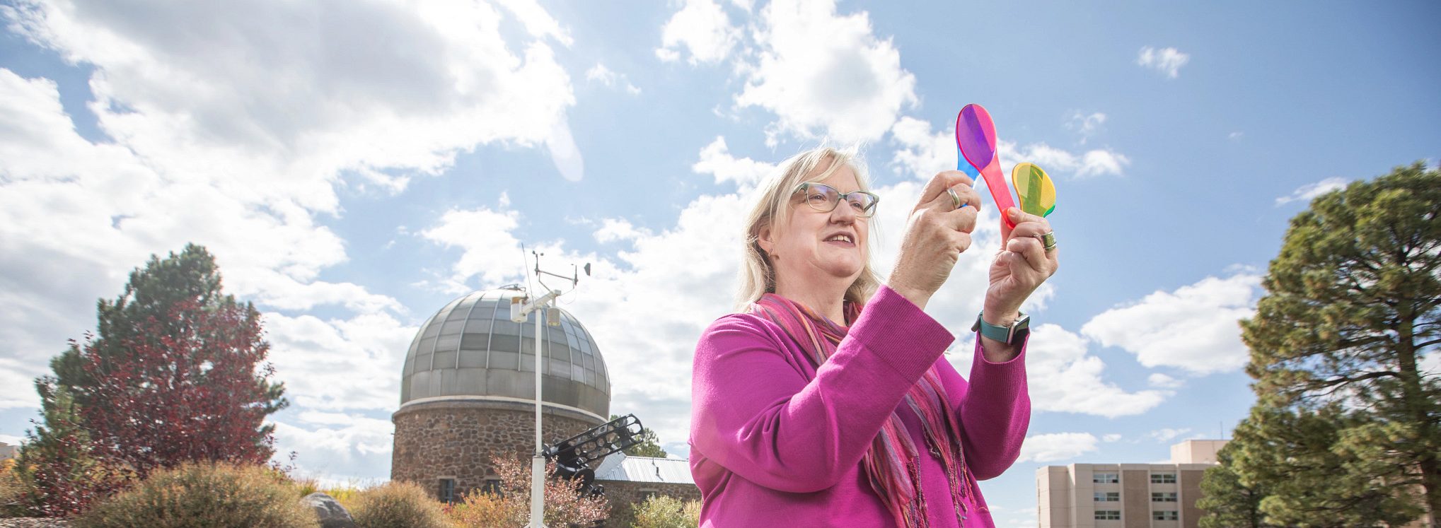 Marti Canipe holding colorful items and looking at them.