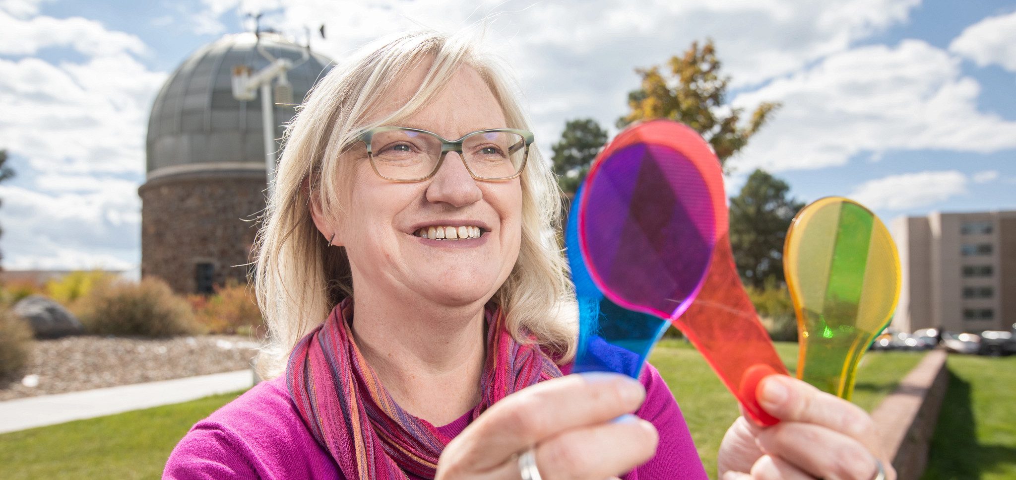Marti Canipe holding colorful items and looking at them.