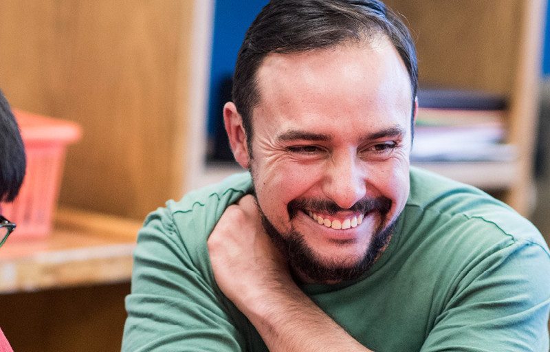Student teacher works with children at a table.