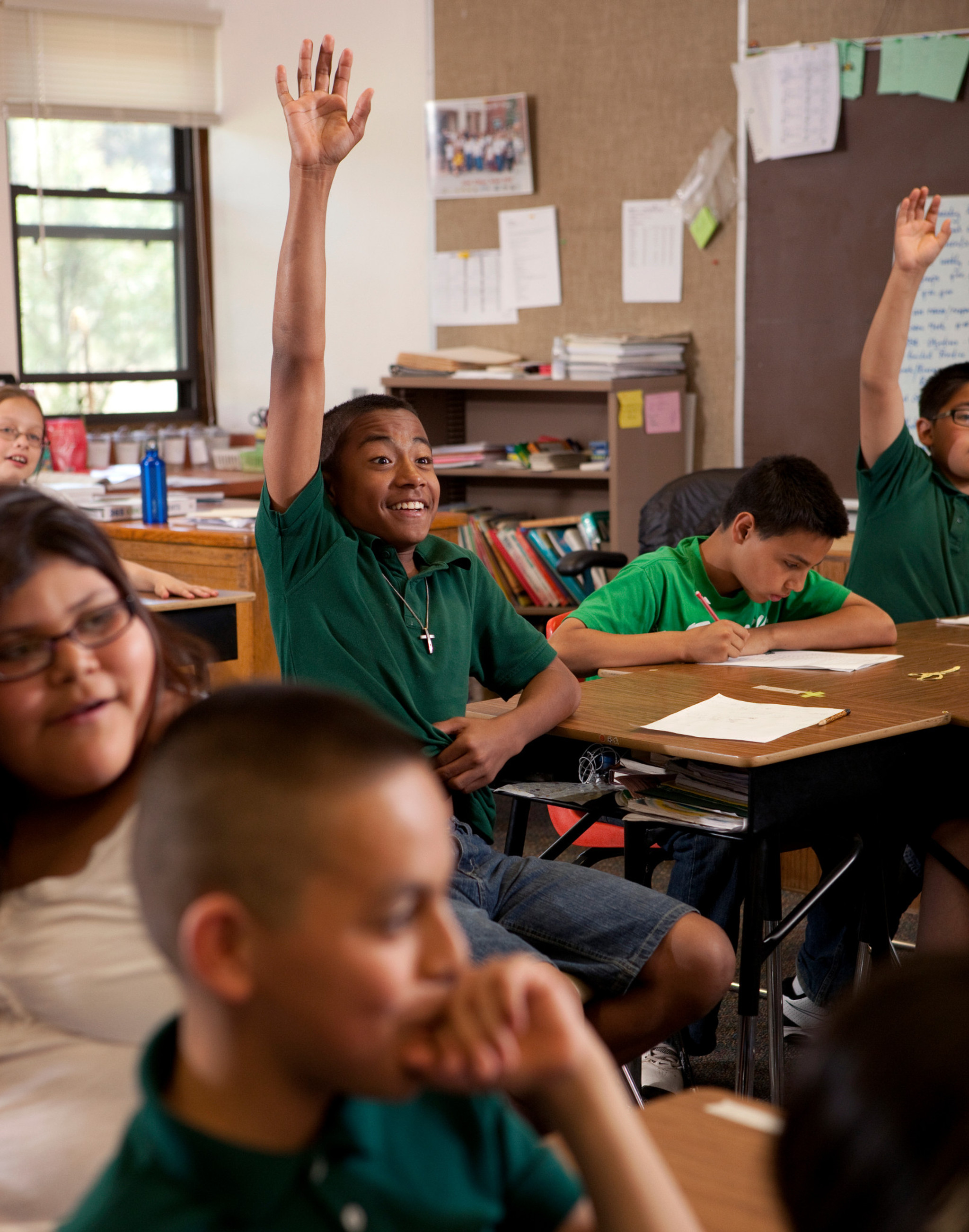 Young student raises hand during class.